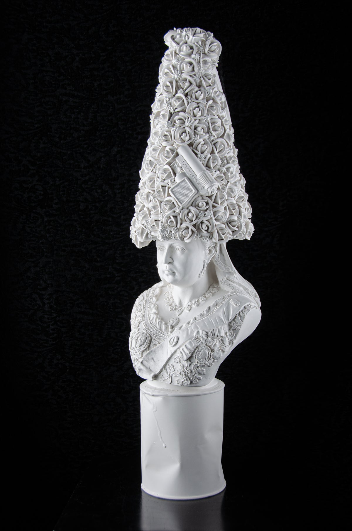 White plaster contemporary sculpture of Queen Victoria wearing a large hat made of tons of roses and a few 1970's squirt guns. She is whimsically eclectic in all white.